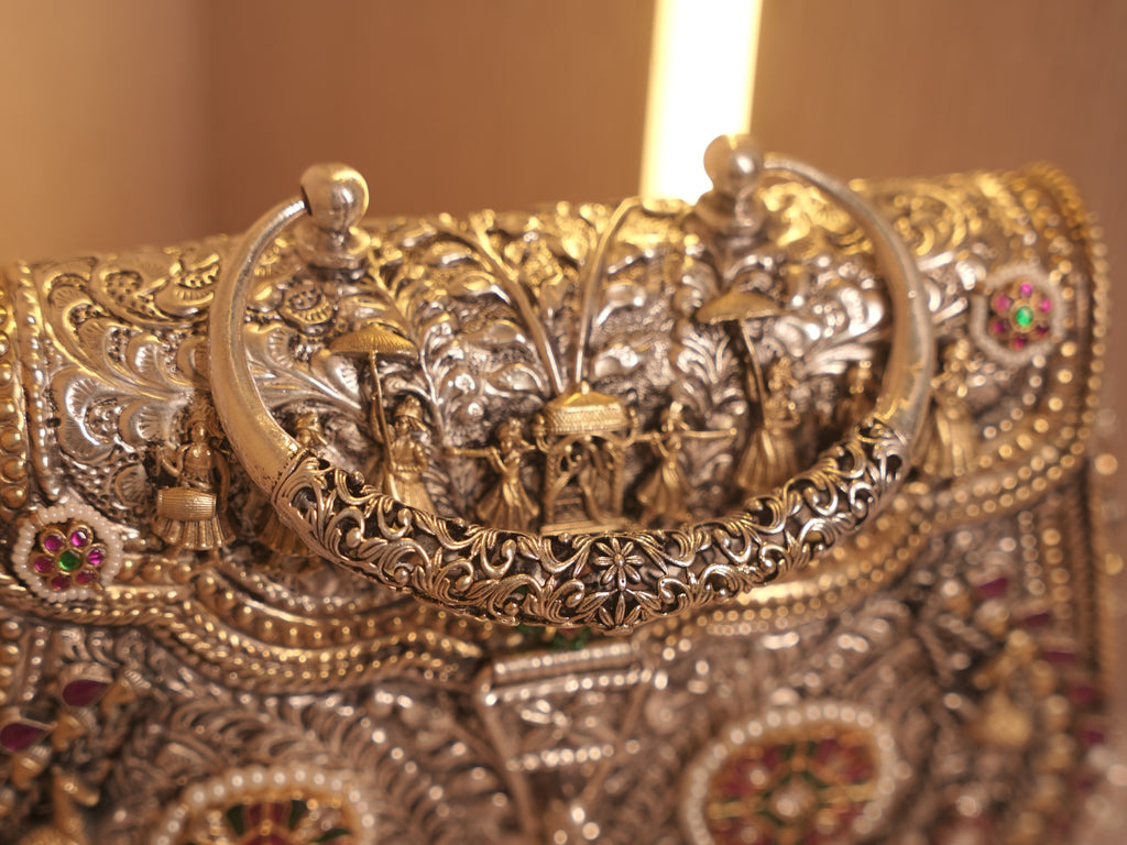 Corner of the purse showing the gold-tone beaded borders and a stone set floral medallion.