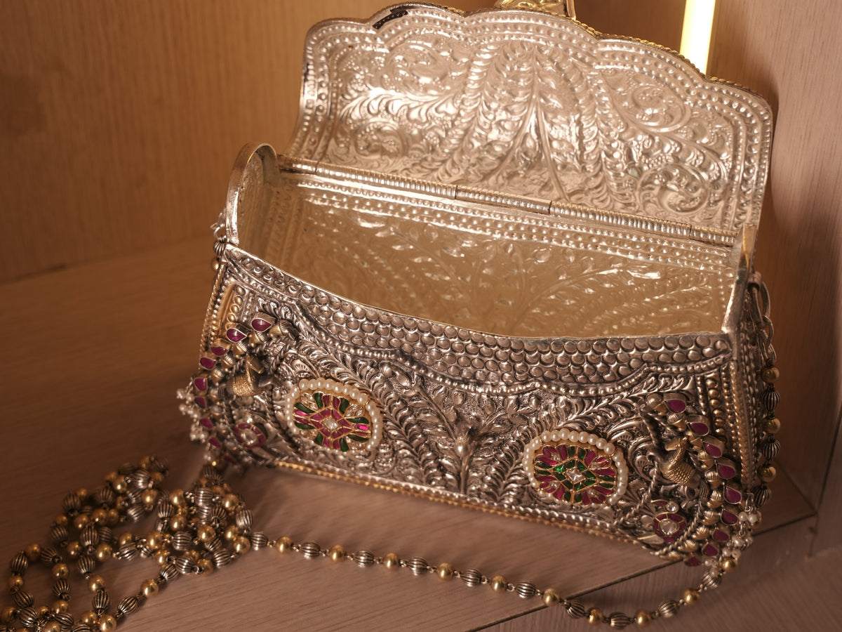 The purse open on its hinge, showing the fully engraved silver interior.