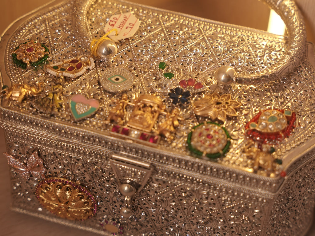 Angled view of the box purse showing the pierced lattice filigree of the sides and the hook clasp.