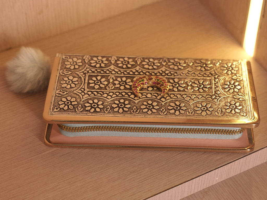 The clutch wallet with its flap raised, showing the zip that closes the wallet and the fabric interior.