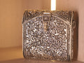Front of the oxidised silver box bag, worked with a repousse vine of flowers and leaves inside beaded borders.