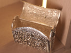 The oxidised box bag open on its hinge, showing the polished interior behind the floral front.