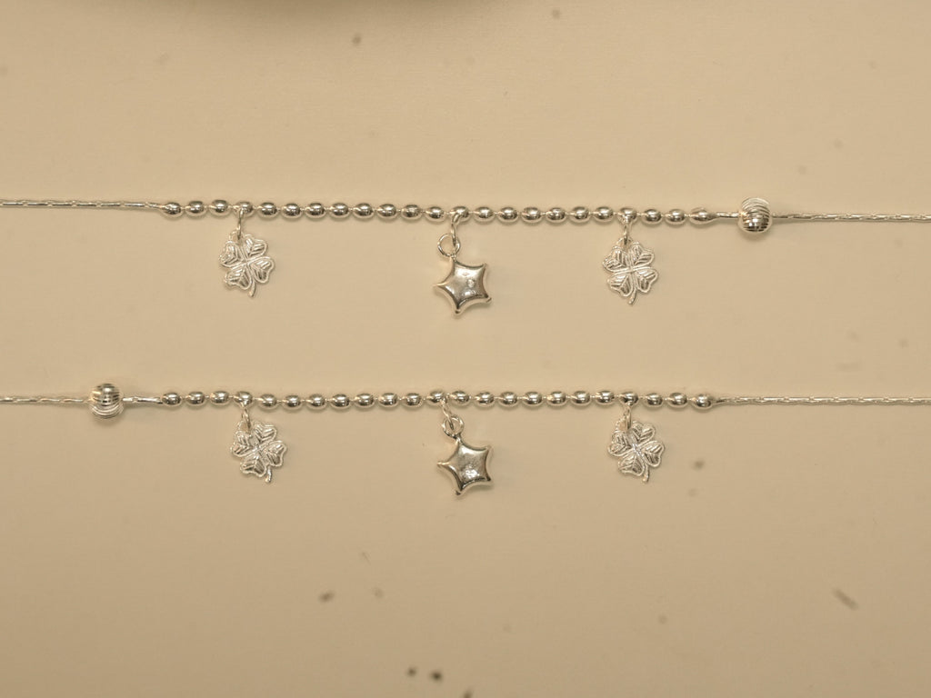 Pair of sterling silver payal with rice bead centres, each carrying two clover charms and a puffed star.