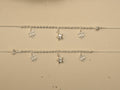 Pair of sterling silver payal with rice bead centres, each carrying two clover charms and a puffed star.
