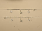 Pair of sterling silver payal with rice bead centres, each carrying two clover charms and a puffed star.
