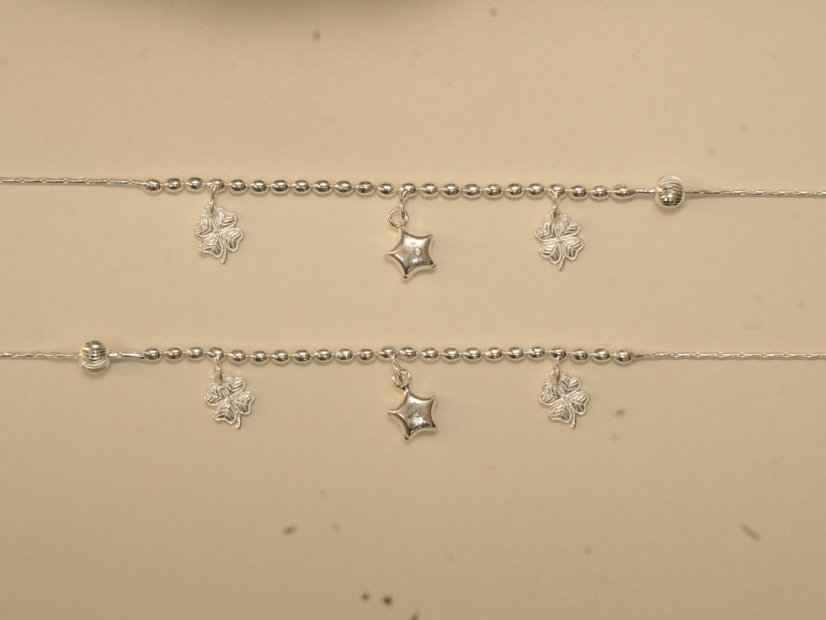 Pair of sterling silver payal with rice bead centres, each carrying two clover charms and a puffed star.