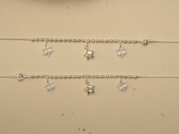 Pair of sterling silver payal with rice bead centres, each carrying two clover charms and a puffed star.