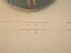 The pair of clover and star payal laid out full length, showing the spring ring clasps.