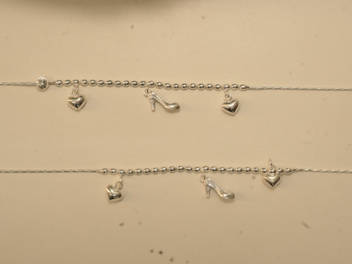 Pair of sterling silver payal with rice bead centres, each carrying two puffed hearts and a high-heeled shoe charm.