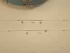 The pair of heart and heel payal laid out to show the charms and the extender chain.