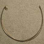 Sterling silver anklet with gold-tone and rose gold-tone strands photographed from above on textured cloth.