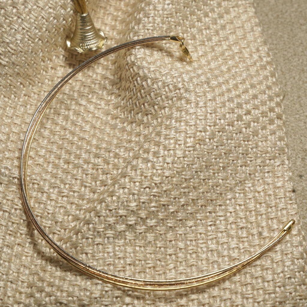Full view of the fine mixed-tone anklet showing its silver, gold-tone and rose gold-tone strands and end cap.