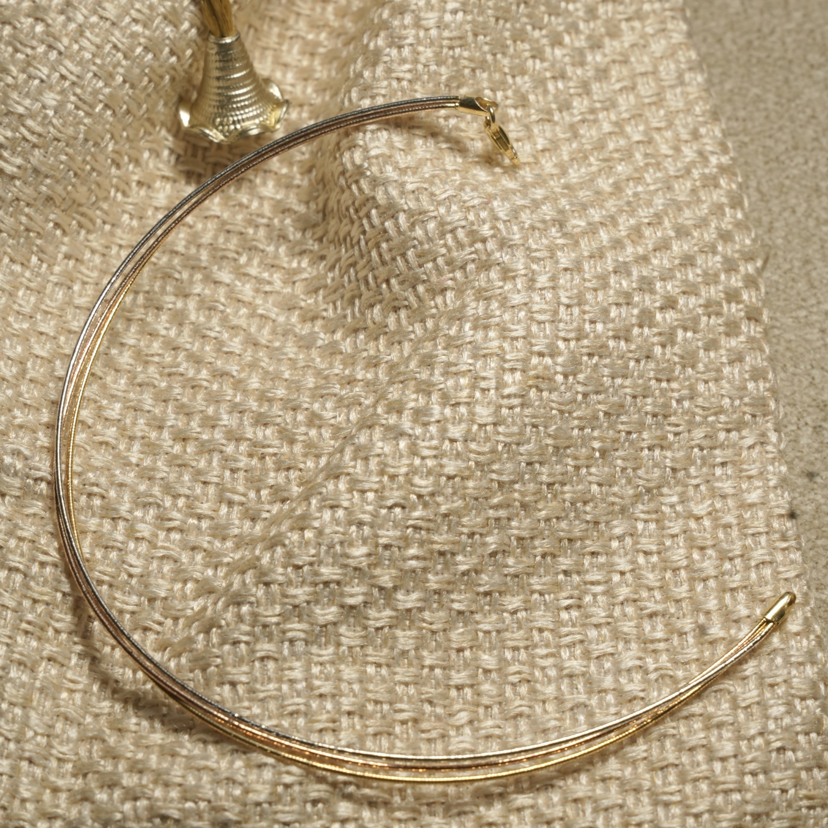 Full view of the fine mixed-tone anklet showing its silver, gold-tone and rose gold-tone strands and end cap.