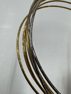 Macro view of the anklet's snake chains, showing the gold-tone and polished silver strands side by side.