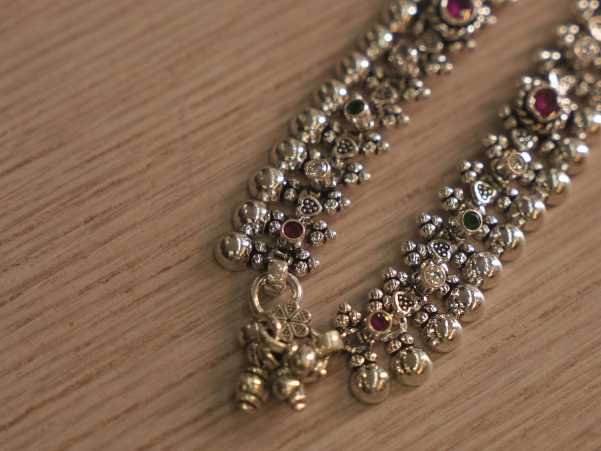 Detail of the silver payal band, showing beaded edges, polished granules and a stone cluster beside the clasp.