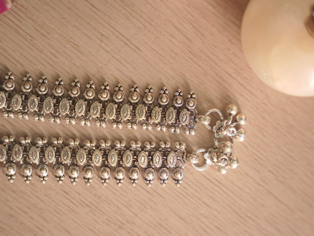 Clasp end of the oxidised silver payal, showing the ring closure and a cluster of ghungroo bells.