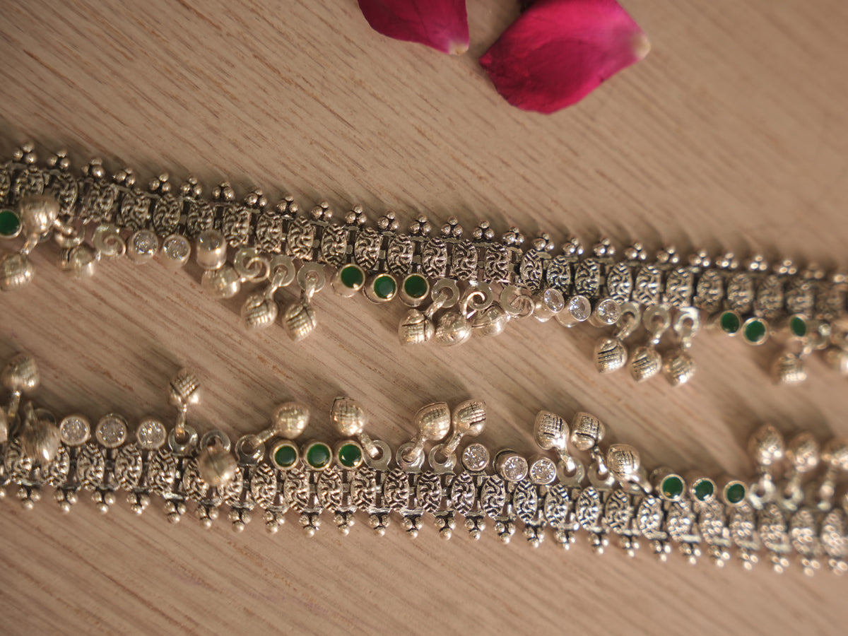 Close view of the oxidised silver payal band, showing textured oval links, tri bead edging and a bezel set green stone.