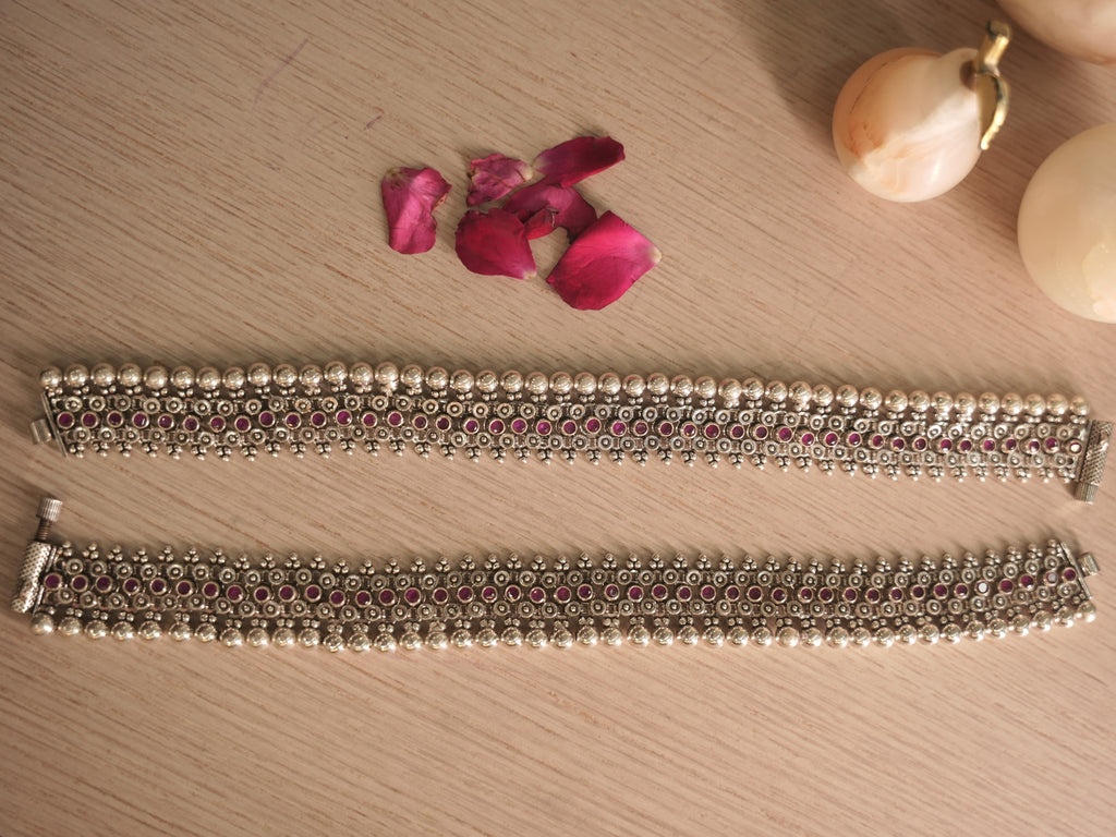 Close view of the payal lattice, with round deep pink glass stones set between silver flowers.