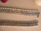 Detail of the silver payal edge, showing polished dome beads beside the floral jaali.