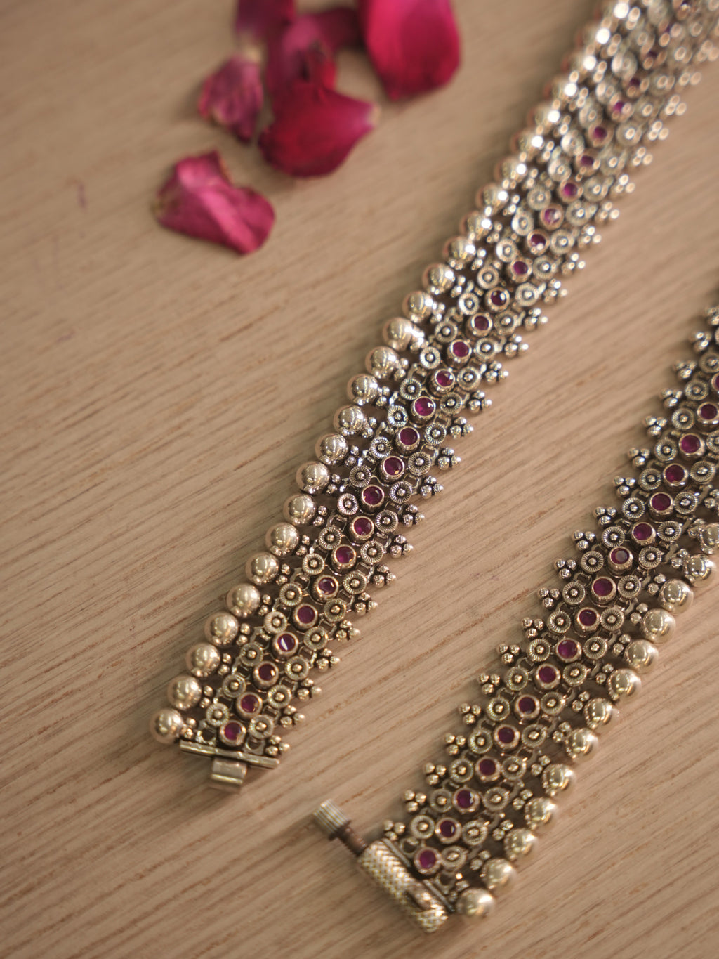 Angled detail of the silver payal, showing the pink glass stone rows catching the light.