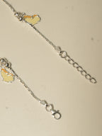 Close view of the lobster clasp, the extender chain and two enamel butterflies.