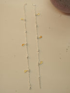 The pair of silver butterfly payal laid out full length, showing the spacing of the butterflies.