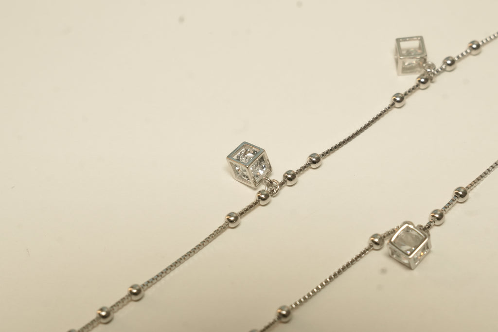 Close view of the cube charms and polished bead stations on the silver payal.