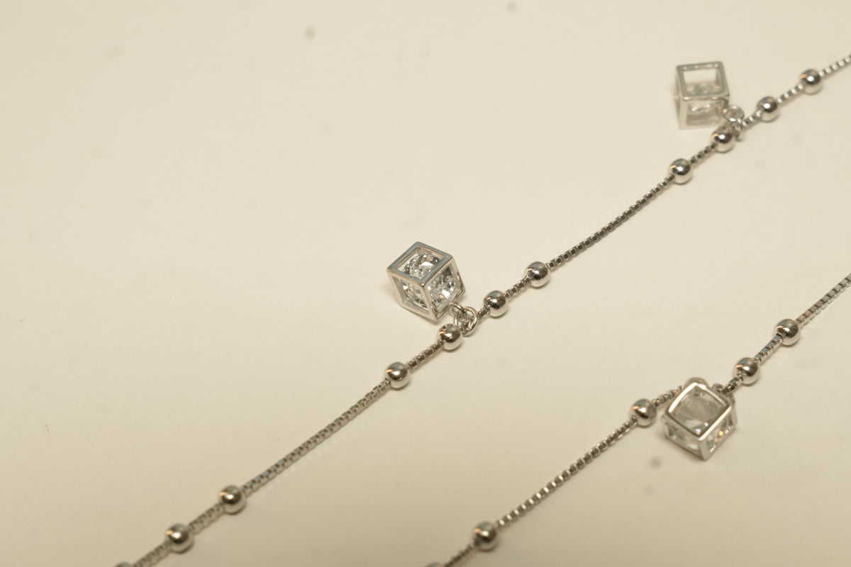 Close view of the cube charms and polished bead stations on the silver payal.