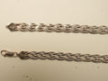 Pair of rose gold plated braided herringbone silver payal laid side by side, showing the lobster clasp and the stamped end caps.