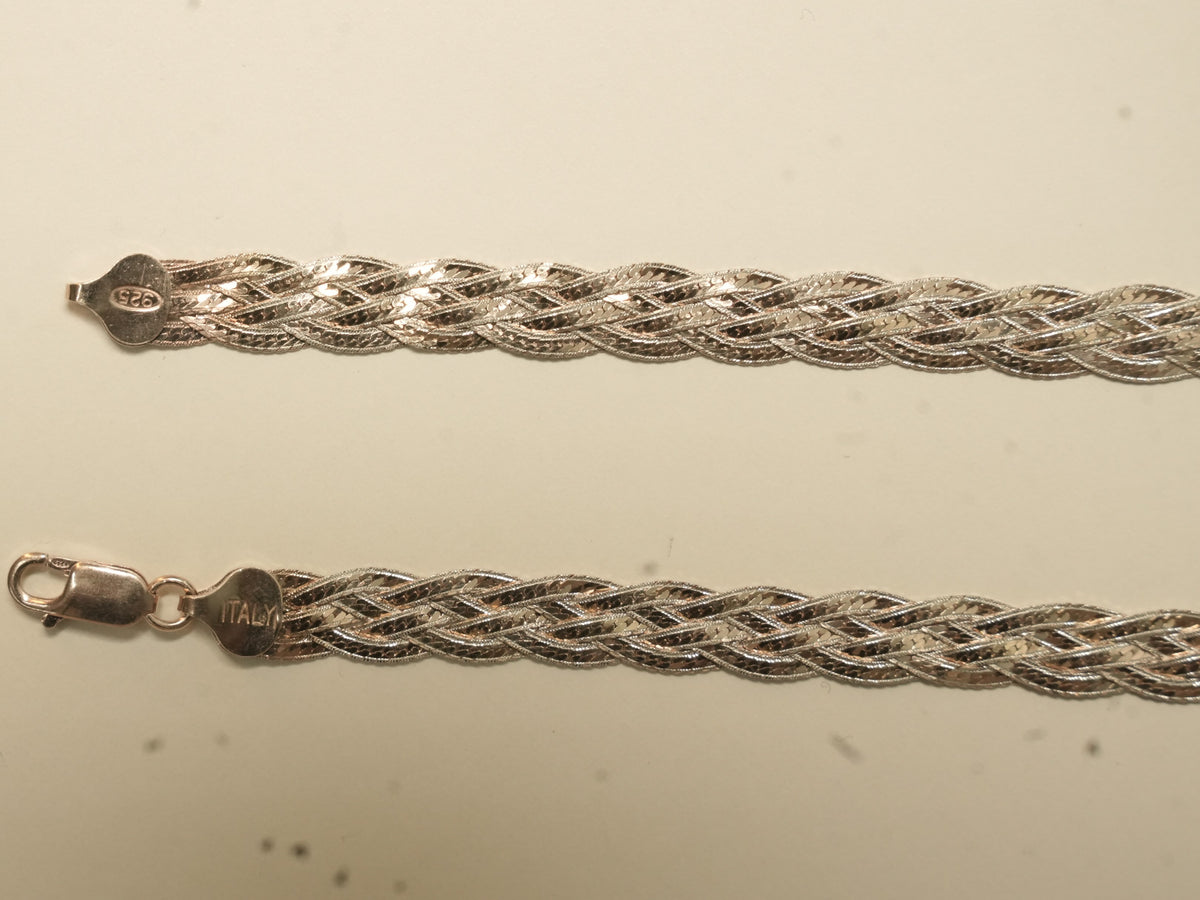 Pair of rose gold plated braided herringbone silver payal laid side by side, showing the lobster clasp and the stamped end caps.