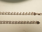 Close view of the braided herringbone ribbon and the end caps on the rose gold plated payal.
