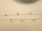 The pair of silver payal laid out full length, showing the paperclip links and the extender chain.