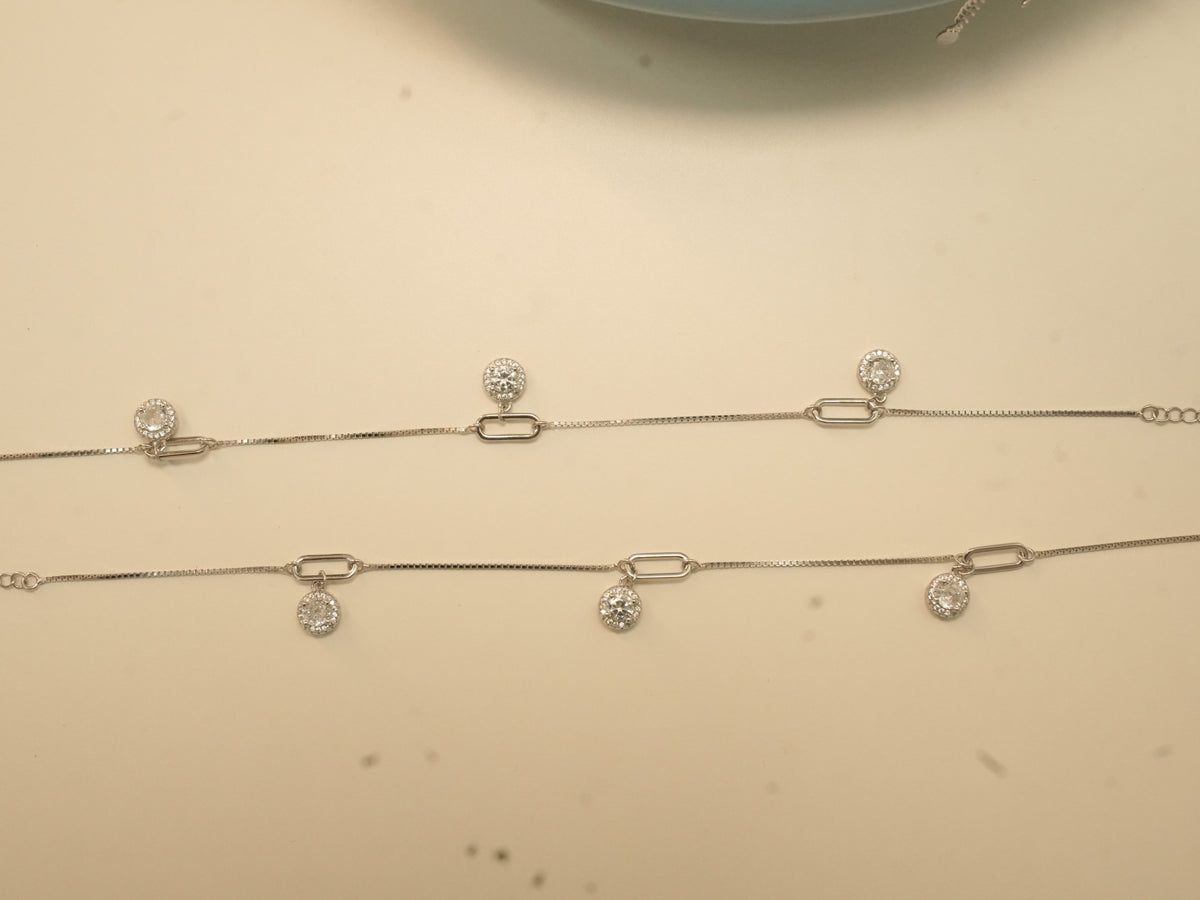 The pair of silver payal laid out full length, showing the paperclip links and the extender chain.