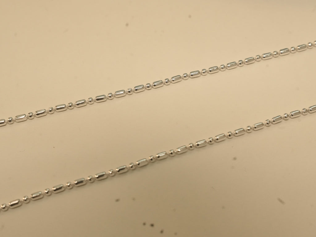 Close view of the alternating bars and round beads on the silver payal.