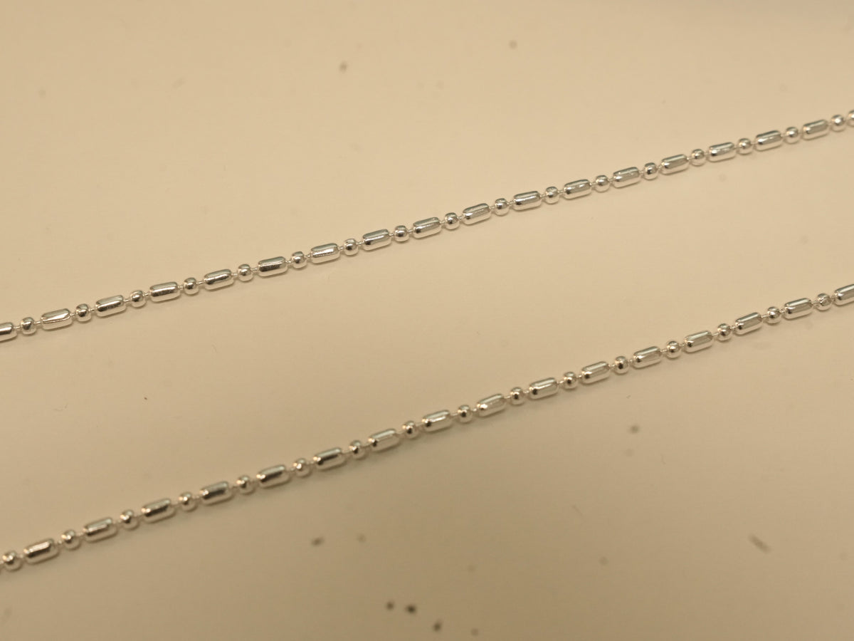 Close view of the alternating bars and round beads on the silver payal.