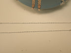 The pair of bar and bead silver payal laid out full length.