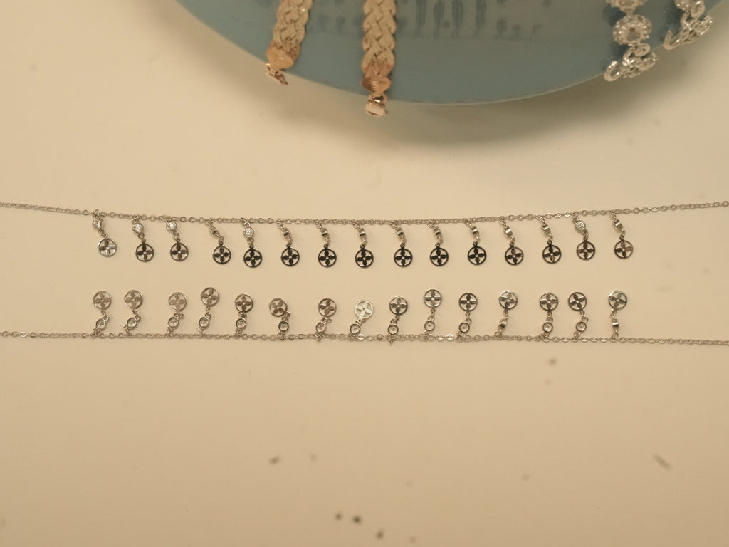 The pair of flower disc fringe payal laid out full length.