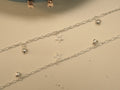 Pair of silver figaro chain payal, each with puffed heart charms and an open star.