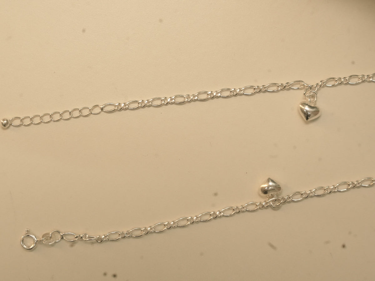 Spring ring clasp, extender chain and puffed heart charms on the figaro chain payal.