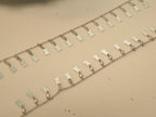 Close view of the scalloped silver tags and bezel set stones on the payal.