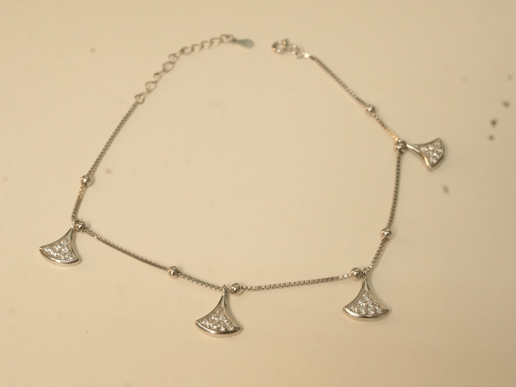 Sterling silver anklet with four fan shaped American Diamond charms, laid in a loop.