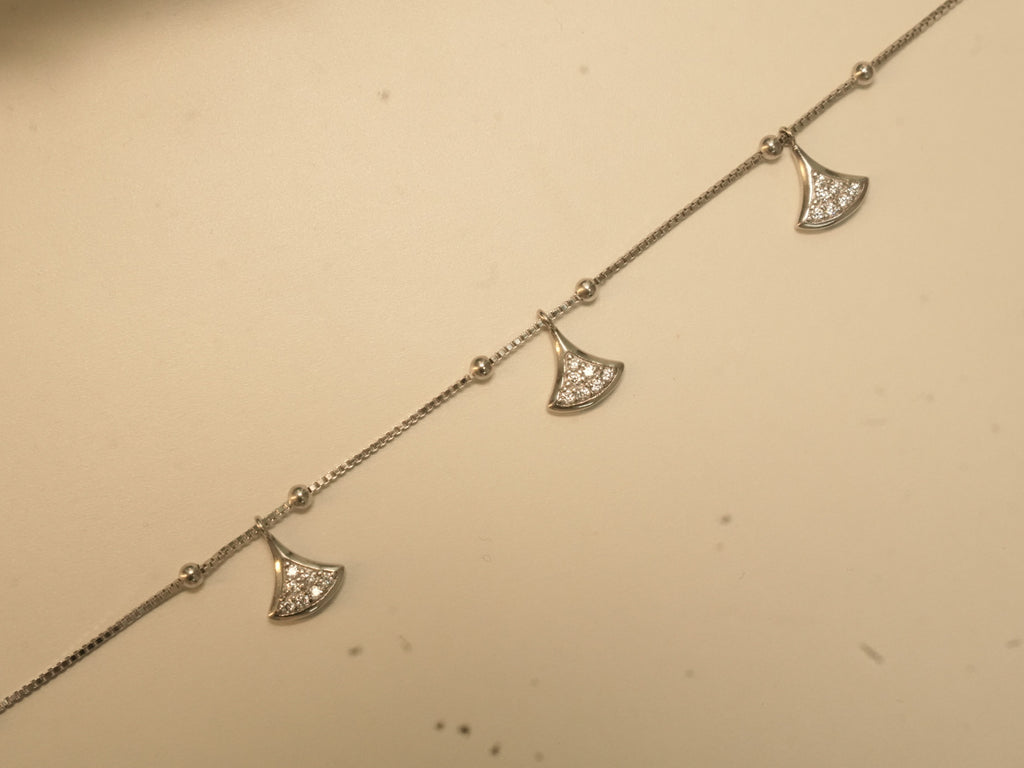 Close view of three pave set fan charms on the box chain anklet.