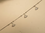 Close view of three pave set fan charms on the box chain anklet.