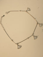 The fan charm anklet laid in a loop, showing the spring ring clasp and the extender chain.
