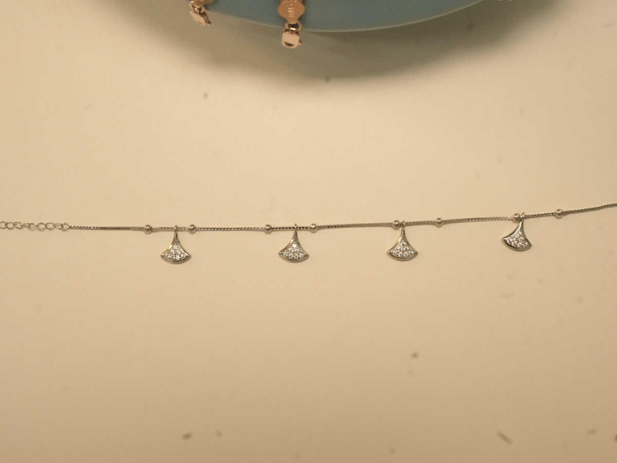 The fan charm anklet laid out straight, showing the four charms.