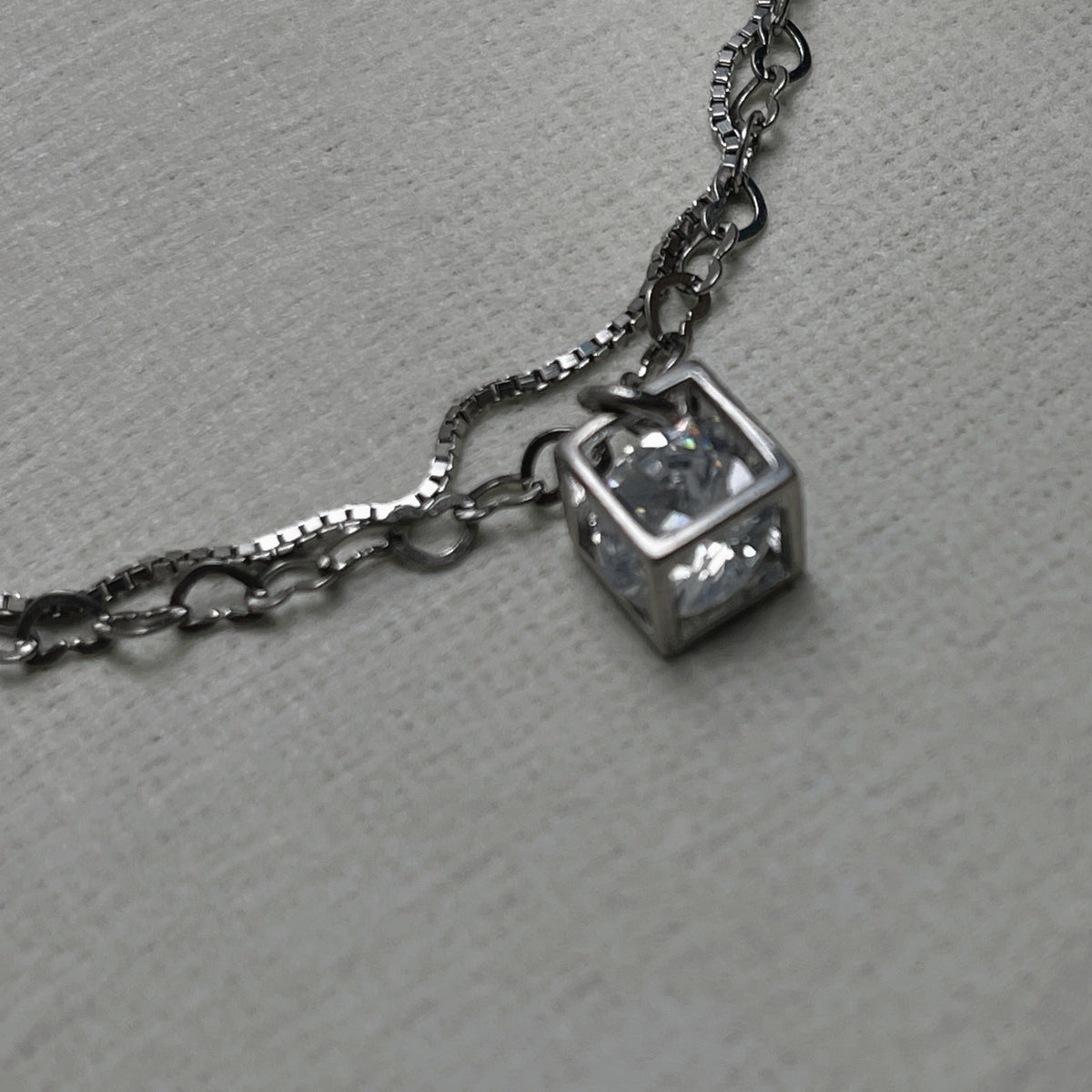 Close-up of the open silver cube with the American Diamond held inside it.