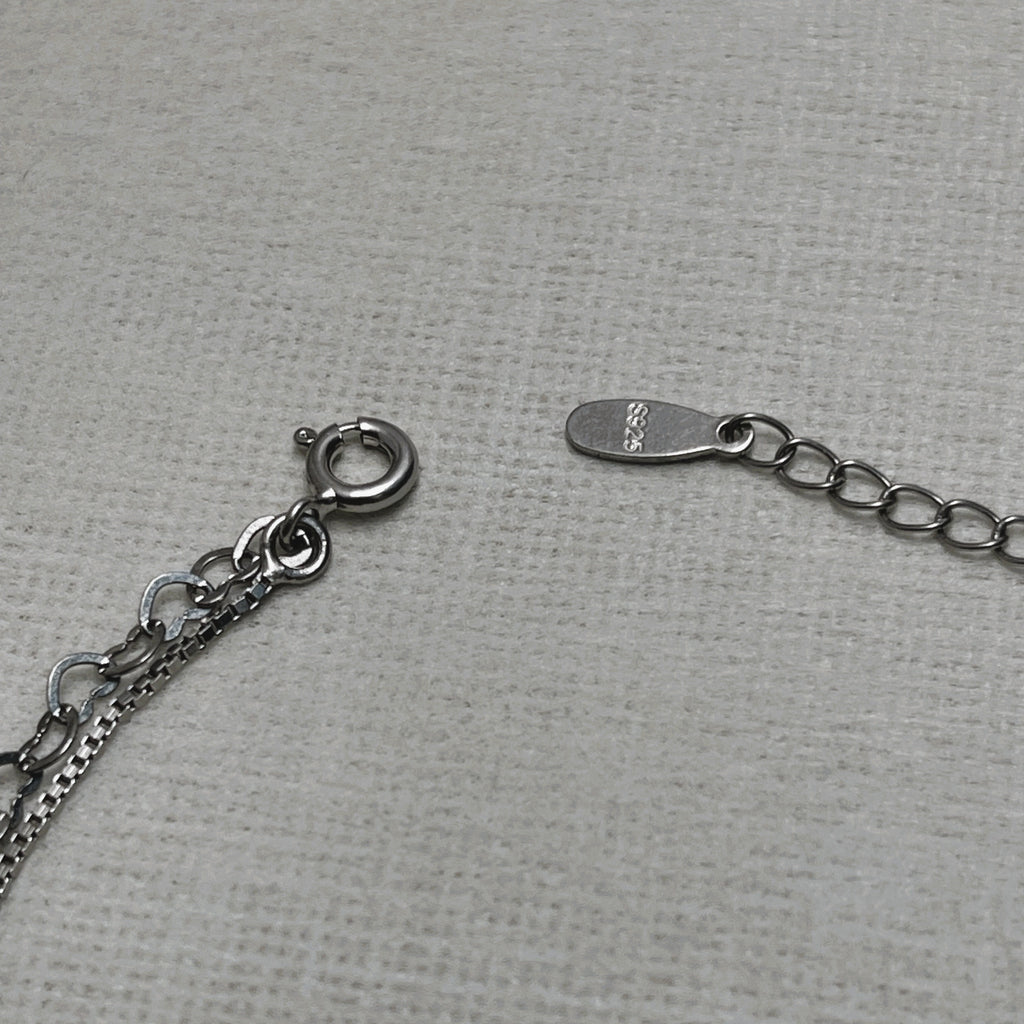The spring ring clasp and extender chain of the anklet, with the 925 stamped tag.