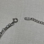 The spring ring clasp and extender chain of the anklet, with the 925 stamped tag.