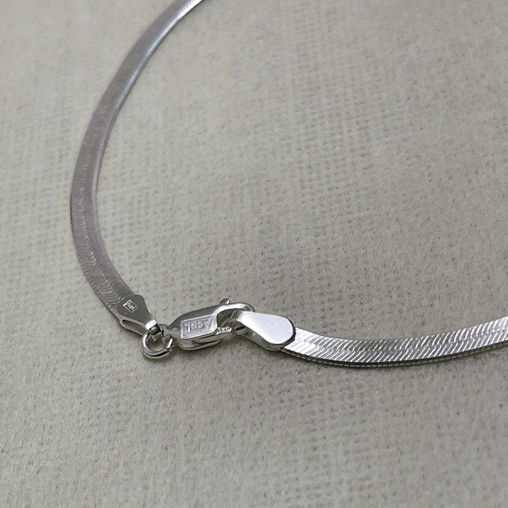 Close-up of the herringbone links and lobster clasp of the payal pair.
