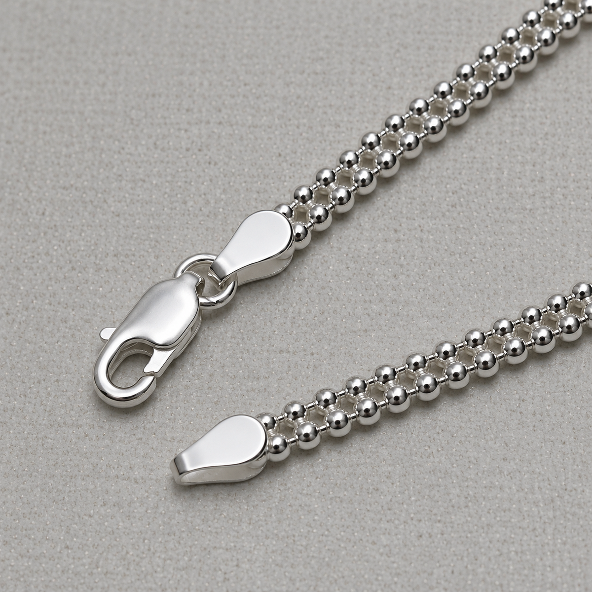 Close-up of the beaded popcorn links and the lobster clasp of the silver anklet.
